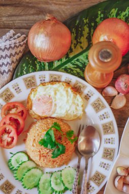 Kızarmış pilav ve yumurta ahşap masaya koyun ve domates, salatalık, sarımsak, arpacık soğanı