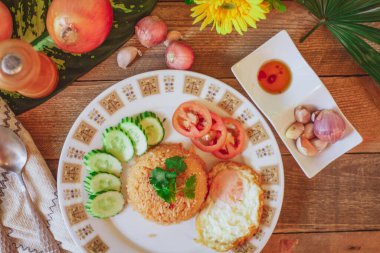 Kızarmış pilav ve yumurta ahşap masaya koyun ve domates, salatalık, sarımsak, arpacık soğanı