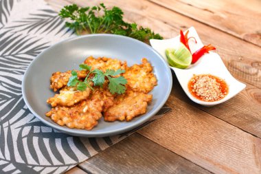 Tahta masaya acı biber soslu mısır cipsi.