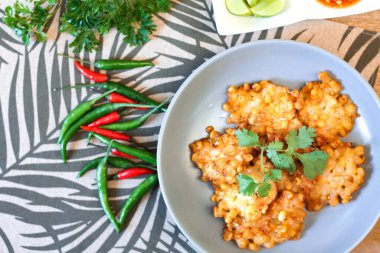 Tahta masaya acı biber soslu mısır cipsi.