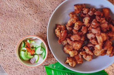 Balık soslu kızarmış domuz eti ve siyah ahşap zeminde beyaz tabakta servis edilen yapışkan pirinç..