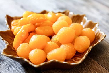 Tayland Tatlıları: Yaprak şeklinde tabaklar üzerinde altın ve meyve tohumları.