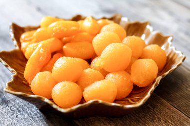 Tayland Tatlıları: Yaprak şeklinde tabaklar üzerinde altın ve meyve tohumları.