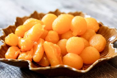 Tayland Tatlıları: Yaprak şeklinde tabaklar üzerinde altın ve meyve tohumları.