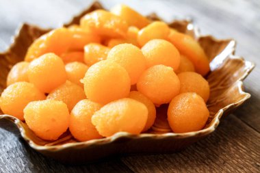 Tayland Tatlıları: Yaprak şeklinde tabaklar üzerinde altın ve meyve tohumları.