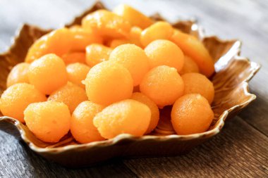 Tayland Tatlıları: Yaprak şeklinde tabaklar üzerinde altın ve meyve tohumları.