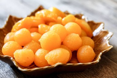 Tayland Tatlıları: Yaprak şeklinde tabaklar üzerinde altın ve meyve tohumları.