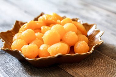 Tayland Tatlıları: Yaprak şeklinde tabaklar üzerinde altın ve meyve tohumları.