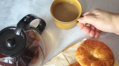 Kahveyle servis edilen bir kruvasan beyaz bir masaya konur..