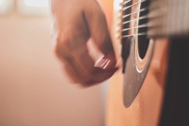 Gitarist yan ışıklandırmalı bir odada gitar çalıyor..