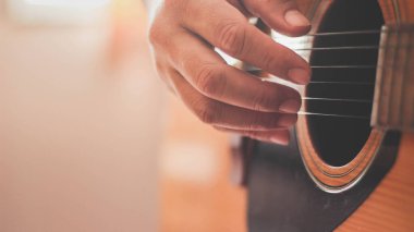 Gitarist yan ışıklandırmalı bir odada gitar çalıyor..