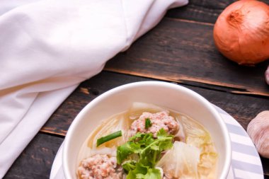 Kaynamış tofu ve kıymalı domuz eti, siyah ahşap masada servis edilen beyaz bardaklarda servis edilir..