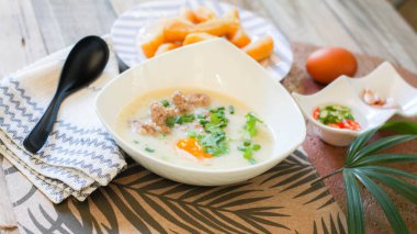 Çin usulü yulaf lapası, yulaf lapası ve kızarmış hamur çubuğu ya da kızarmış hamur çubuğu ya da çörek ya da ahşap masaya yerleştirilmiş kızarmış ekmek. Tayland sokak yemeklerine 