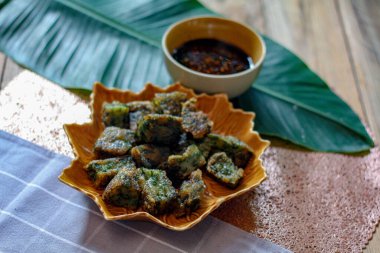 Yaprak şekilli tabaklar ve soya sosu üzerine Çin Chive Hamur köfteleri muz yapraklarıyla ahşap bir masaya koyun.