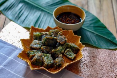 Yaprak şekilli tabaklar ve soya sosu üzerine Çin Chive Hamur köfteleri muz yapraklarıyla ahşap bir masaya koyun.