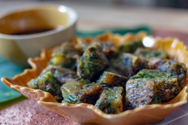 Yaprak şekilli tabaklar ve soya sosu üzerine Çin Chive Hamur köfteleri muz yapraklarıyla ahşap bir masaya koyun.