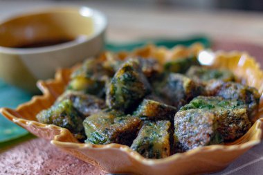 Yaprak şekilli tabaklar ve soya sosu üzerine Çin Chive Hamur köfteleri muz yapraklarıyla ahşap bir masaya koyun.