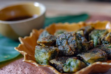 Yaprak şekilli tabaklar ve soya sosu üzerine Çin Chive Hamur köfteleri muz yapraklarıyla ahşap bir masaya koyun.