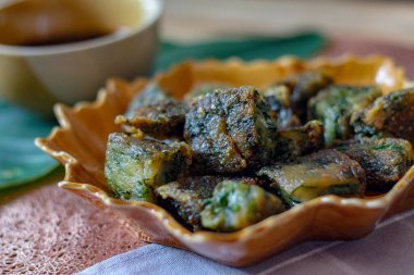 Yaprak şekilli tabaklar ve soya sosu üzerine Çin Chive Hamur köfteleri muz yapraklarıyla ahşap bir masaya koyun.