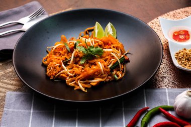 Tayland Gıda Pad Thai 'si (Tayland ulusal yemeği) Siyah tabakta limon ve baharat.