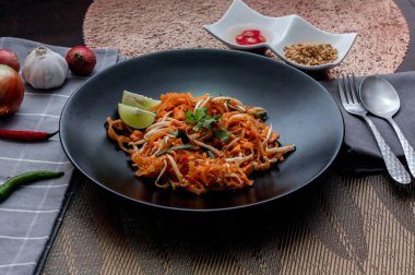 Tayland Gıda Pad Thai 'si (Tayland ulusal yemeği) Siyah tabakta limon ve baharat.