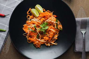Tayland Gıda Pad Thai 'si (Tayland ulusal yemeği) Siyah tabakta limon ve baharat.