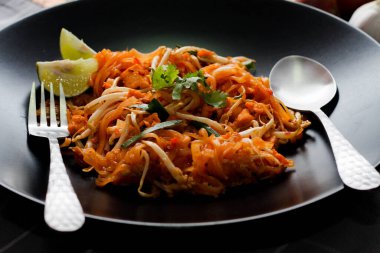Tayland Gıda Pad Thai 'si (Tayland ulusal yemeği) Siyah tabakta limon ve baharat.