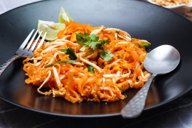 Tayland Gıda Pad Thai 'si (Tayland ulusal yemeği) Siyah tabakta limon ve baharat.