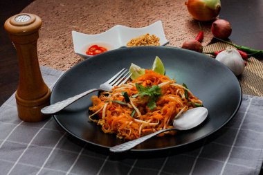 Tayland Gıda Pad Thai 'si (Tayland ulusal yemeği) Siyah tabakta limon ve baharat.