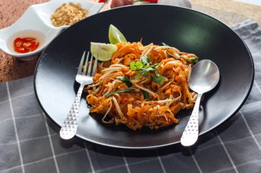 Tayland Gıda Pad Thai 'si (Tayland ulusal yemeği) Siyah tabakta limon ve baharat.