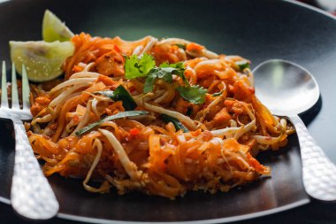 Tayland Gıda Pad Thai 'si (Tayland ulusal yemeği) Siyah tabakta limon ve baharat.
