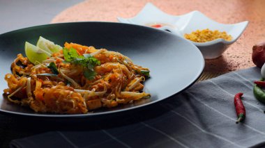 Tayland Gıda Pad Thai 'si (Tayland ulusal yemeği) Siyah tabakta limon ve baharat.