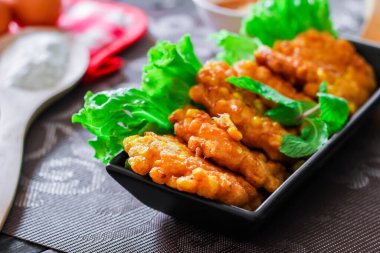 Siyah ahşap bir masaya konmuş acı biber soslu mısır cipsi.