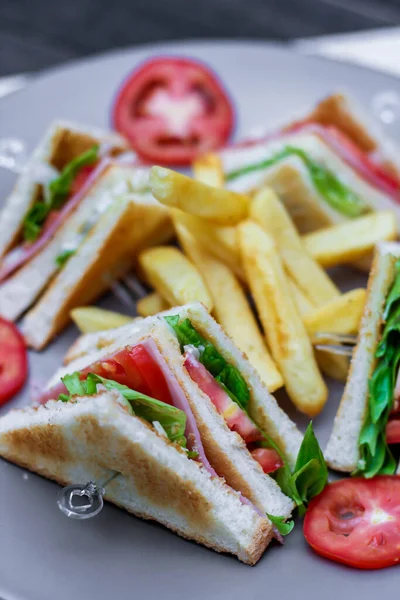 Sanduíche Clube Fatias Dispostas Prato Cinza Com Tomates Batatas Fritas — Fotografia de Stock