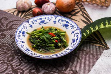 Çin desenli bir tabakta servis edilen yeşil yapraklar, soğanlar ve soğan aromalı soya fasulyesi ezmesiyle Kızarmış Sabah Zaferi..