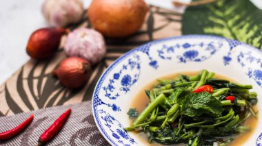 Çin desenli bir tabakta servis edilen yeşil yapraklar, soğanlar ve soğan aromalı soya fasulyesi ezmesiyle Kızarmış Sabah Zaferi..