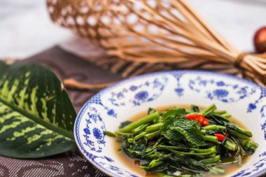 Çin desenli bir tabakta servis edilen yeşil yapraklar, soğanlar ve soğan aromalı soya fasulyesi ezmesiyle Kızarmış Sabah Zaferi..