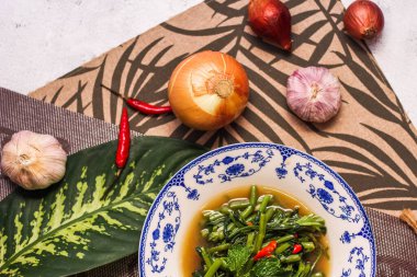 Çin desenli bir tabakta servis edilen yeşil yapraklar, soğanlar ve soğan aromalı soya fasulyesi ezmesiyle Kızarmış Sabah Zaferi..