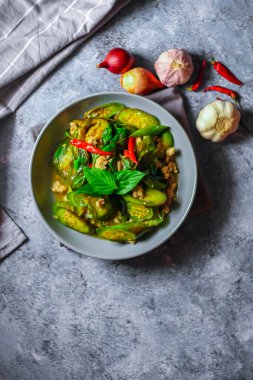 Kızarmış patlıcanla domuz etini yeşil bir tabakta masanın üstünde kurutulmuş sarımsaklı biberle karıştırın.