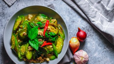 Kızarmış patlıcanla domuz etini yeşil bir tabakta masanın üstünde kurutulmuş sarımsaklı biberle karıştırın.