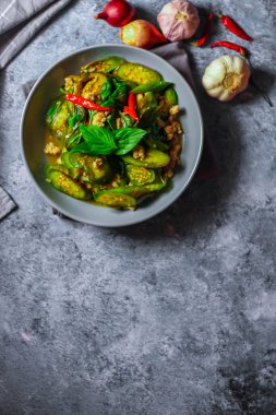 Kızarmış patlıcanla domuz etini yeşil bir tabakta masanın üstünde kurutulmuş sarımsaklı biberle karıştırın.