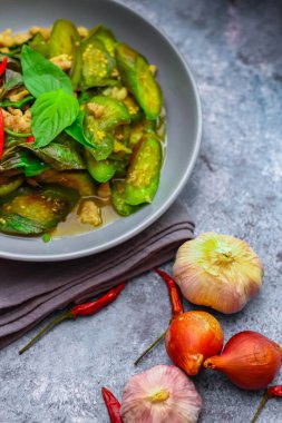 Kızarmış patlıcanla domuz etini yeşil bir tabakta masanın üstünde kurutulmuş sarımsaklı biberle karıştırın.