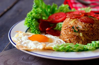 Kızarmış pilav ve Çin sosisi kızarmış yumurta, domates ve marul ile servis edilir..
