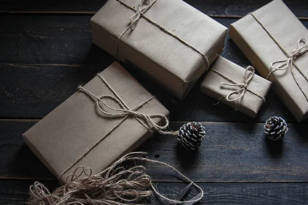 gift wrapping from Kraft paper wrapped with twine, the concept of handmade, placed on black wooden table