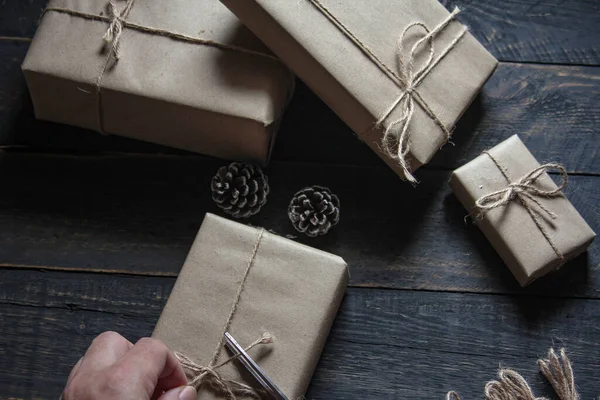 gift wrapping from Kraft paper wrapped with twine, the concept of handmade, placed on black wooden table