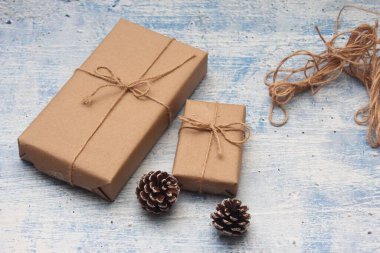 İplikle sarılmış Kraft kağıdından hediye paketi, el yapımı konsept, açık mavi masa üstü.