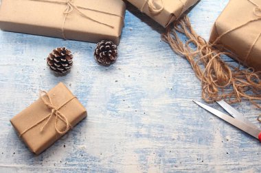 İplikle sarılmış Kraft kağıdından hediye paketi, el yapımı konsept, açık mavi masa üstü.