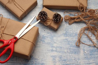 İplikle sarılmış Kraft kağıdından hediye paketi, el yapımı konsept, açık mavi masa üstü.