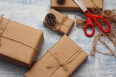 İplikle sarılmış Kraft kağıdından hediye paketi, el yapımı konsept, açık mavi masa üstü.