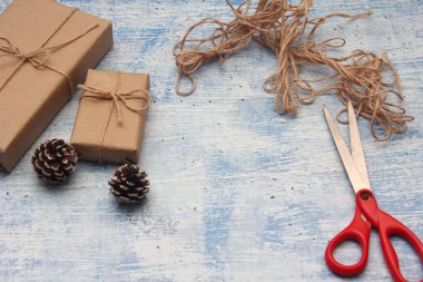 İplikle sarılmış Kraft kağıdından hediye paketi, el yapımı konsept, açık mavi masa üstü.